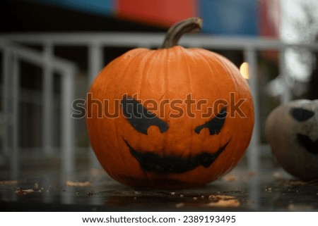 Scary pumpkin. Celebration of the holiday. Black eyes painted on a pumpkin. Day of Evil Spirits.