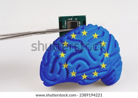 On a white background, a model of the brain with a picture of a flag - EU, a microcircuit, a processor, is implanted into it. Close-up