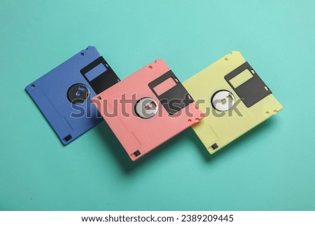 Floating colored retro 80s floppy disks on a blue background. Conceptual pop, creative layout