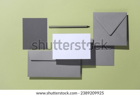 Floating envelopes with card on green background with shadow. Minimalism, modern business still life, creative layout