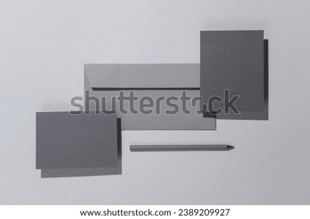 Floating envelope with cards and pencil on gray background with shadow. Minimalism, modern business still life