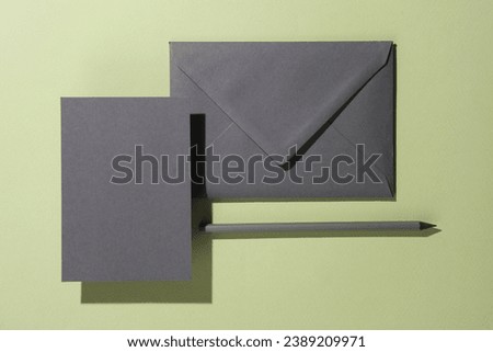Floating envelope with invitation card on green background with shadow. Minimalism, modern business still life