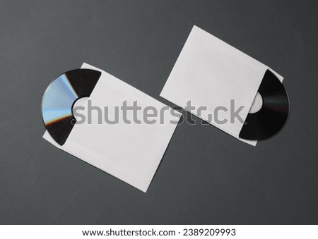 Mockup of CD discs in Paper packs on dark gray background