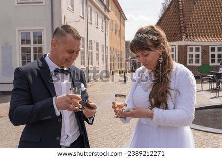 The bride and groom after the ceremony are holding a glass of champagne in their hands. Celebration of the occasion. Wedding 