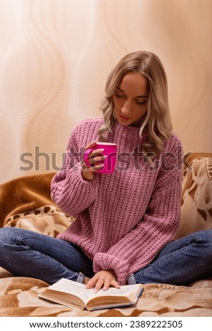 Woman with book and tea sitting on sofa. Retro style. Knowledge Day. High quality photo