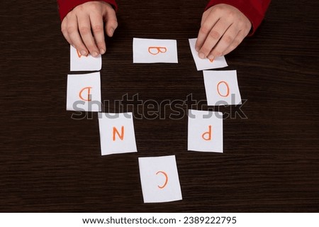 Lesson in elementary school. Cards with the English alphabet. The child learns letters. Teaching in kindergarten. Educational games. Child in kindergarten.