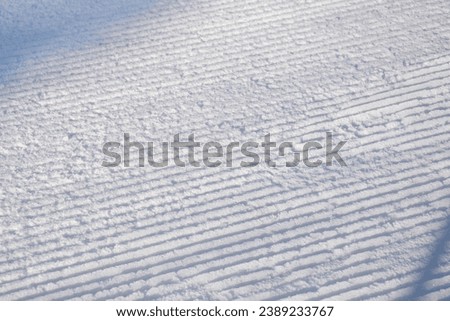 Detail of a ski slope with traces of ratrak in snow