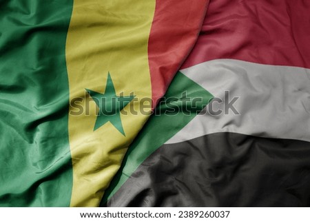 big waving national colorful flag of senegal and national flag of sudan . macro