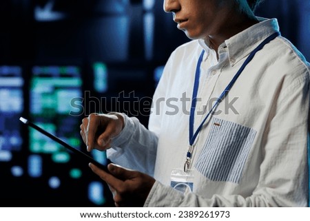 Meticulous programmer between server units providing processing resources for companies worldwide. Seasoned developer fixes high tech workplace supercomputers used for storing large databases Royalty-Free Stock Photo #2389261973