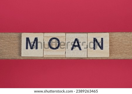 text the word moan from gray wooden small letters with black font on an red table
 Royalty-Free Stock Photo #2389263465