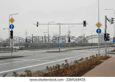 highway in the city, road signs and traffic lights against a gray sky.