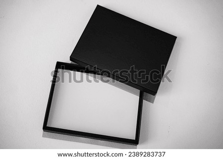 top view of an empty black voucher gift box with white paper placeholder as mockup for black friday offers on a white background

