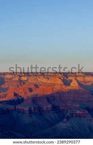 Beautiful rock formations glow red and dark blue shadows fill Arizona's Grand Canyon at sunset