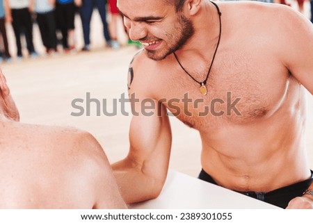 Exuberant young man enjoys arm-wrestling, victory imminent