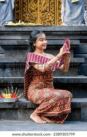 Woman in traditional clothing making an offering at a temple Royalty-Free Stock Photo #2389305799