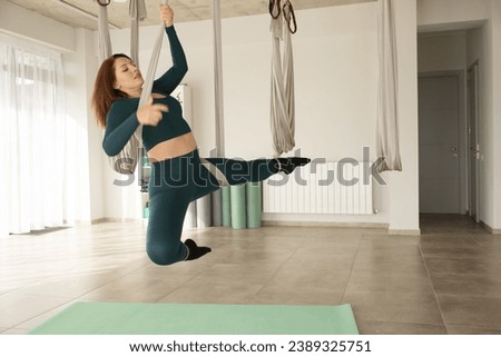 Young girl do fly yoga and stretches, yoga training, fly yoga, aero stretching, aerial yoga hammock, pilates therapy concept. Copy space. 