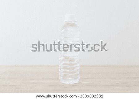 A plastic bottle of drinking water on the desk.
