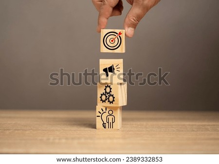 Man put the goal icon on the top off the production plan icon on the wood table. Business plan for production. The product or marketing mix. 4P, Idea, Production, promotion and price.