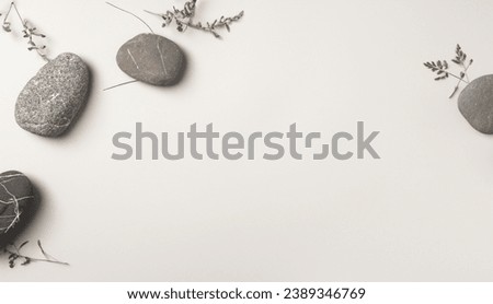 Minimalist round stone Rock and bouquet of dry on gray background. Place, background for cosmetics. Top view. Copy space