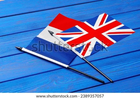 Flags of France and Great Britain on blue wooden background