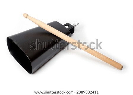 Cowbell percussion musical instrument, black metal with a wooden stick. Royalty-Free Stock Photo #2389382411