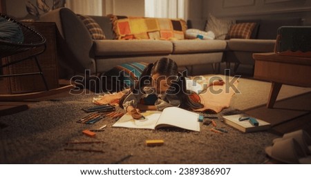 Evening Portrait of Cute Little Girl Drawing while Lying on the Floor in Living Room. Talented Korean Child Being Creative, Coloring Picture, Preparing a Become Famous Artist