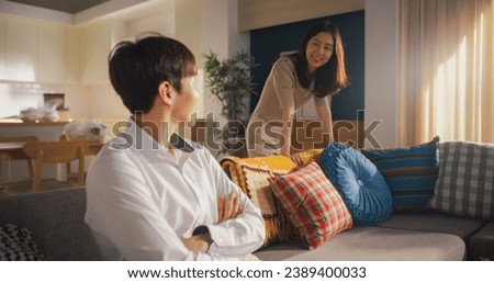 Happy Homeowners Moving In: Lovely Korean Couple in their New Cozy Apartment Unpacking Boxes and Decorating the Sofa. They are Excited for the Future, Celebrating a Milestone in Their Love Story Royalty-Free Stock Photo #2389400033