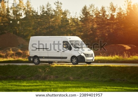 A fast and reliable delivery service with a commercial van on the road. Delivery truck on the highway road. Courier shipping truck. Royalty-Free Stock Photo #2389401957