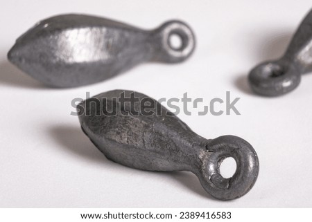 Lead fishing weights cast sinkers isolated on white background. Equipment or tools. Heap of lead sinker weights for fishing, bullet bank accessories Royalty-Free Stock Photo #2389416583