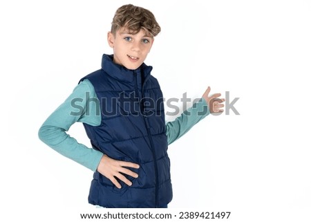 Handsome Caucasian kid boy  feeling happy and cheerful, smiling and welcoming you, inviting you in with a friendly gesture