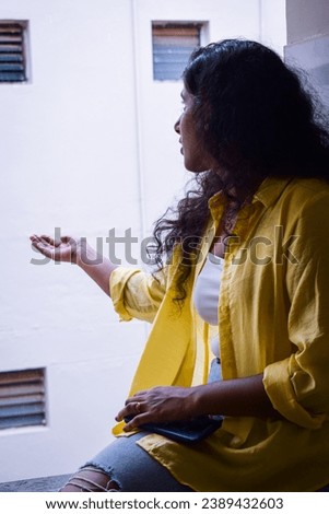 selective focus picture of a woman sitting near the window and enjoying the rain