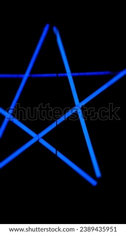 Star blue neon with a dark theme at night. Blurred star neon with a black background. Background abstract light of blue and black ideas. Blue neon light effect at night for parties and nightlife.