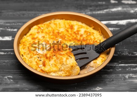 Spiritual Cod is a Portuguese casserole made of salt cod, carrot, bread, Bechamel sauce and topped with cheese closeup in the baking dish.
