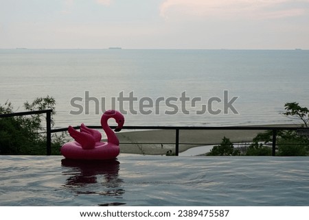 Pink inflatable flamingo floating in swimming pool water