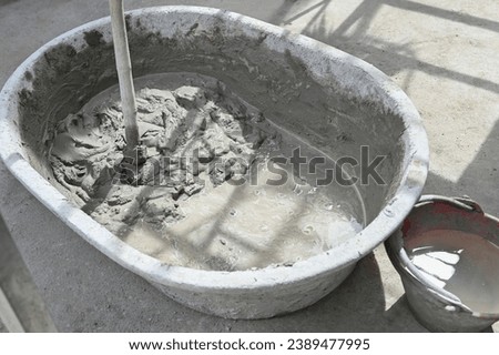 Mixing a cement in salver for applying construction in Thailand Royalty-Free Stock Photo #2389477995