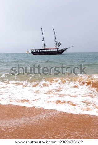 Pirate ship on the high seas, horizontal landscape photo, Tour boat, Piracy on the beach. Brazilian Sea, Ilha Bela. Calm sea. Sand island, blue, sky. Royalty-Free Stock Photo #2389478169