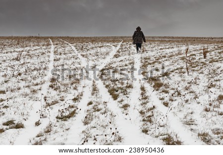 Lonely elderly woman going on one of roads to horizon.