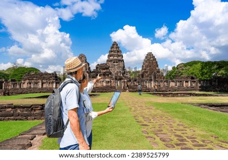 senior couple point index to pagoda,  older adults traveller visit Phimai Historical Park,Nakhon Ratchasima province,Thailand.concept elderly pensioner activity,travelling,archaeological site travel Royalty-Free Stock Photo #2389525799