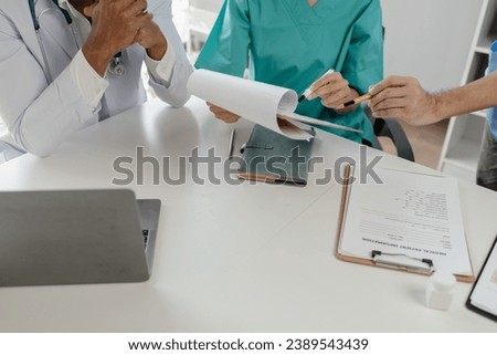 A group of doctors meets together to solve the problem of the epidemic, There was a meeting about major surgery in the hospital, The doctor takes the patient's documents and discusses them with team.
