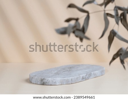 Abstract empty marble board with shadows and leaves on a beige background. Layout concept for promotional product presentation, sale or cosmetics display. Front view and copy space.