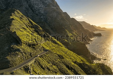 Coastline road at sunset on Gran Canaria Island, Canary Islands, Spain. Majestic volcanic mountains and Atlantic ocean landscape. Aerial view of Gran Canaria coast at sunset. Car trip in Spain Royalty-Free Stock Photo #2389551721