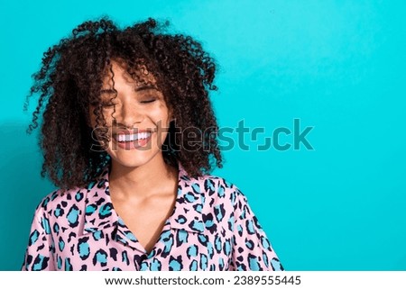 Photo of adorable cheerful girl dressed stylish print clothes presenting empty space beauty salon offer isolated on cyan color background