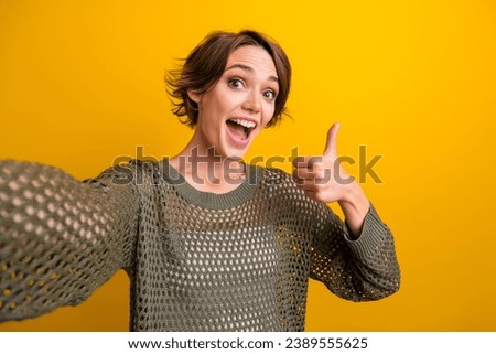 Photo of cheerful glamour girl dressed stylish clothes thumb up recording video feedback isolated on yellow color background