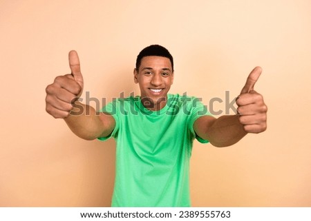 Photo portrait of nice young male showing double thumb up dressed stylish green outfit isolated on beige color background