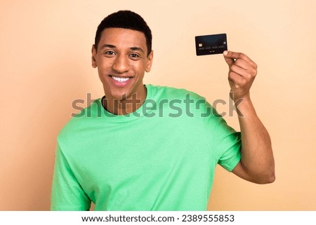 Photo portrait of nice young male hold credit card bunk client agent wear trendy green outfit isolated on beige color background