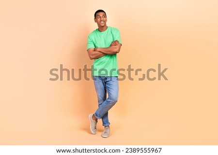 Full length photo of satisfied optimistic man wear stylish t-shirt jeans arms folded look empty space isolated on beige color background