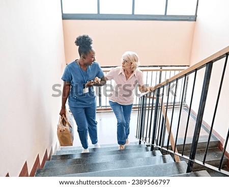 Doctor or nurse caregiver helping disabled senior woman walking down the stairs at home or nursing home Royalty-Free Stock Photo #2389566797