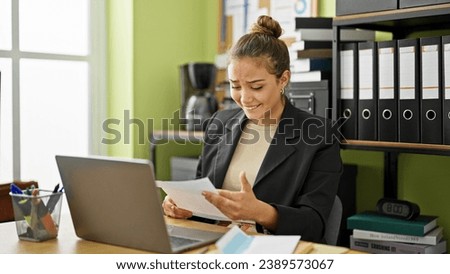 Young beautiful hispanic woman business worker reading letter with surprise expression at office