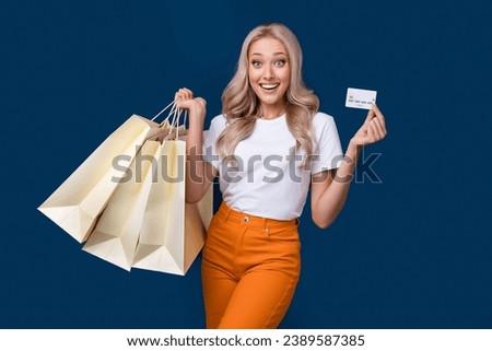 Photo of excited cheerful girl dressed stylish clothes payment by credit card isolated on dark blue color background