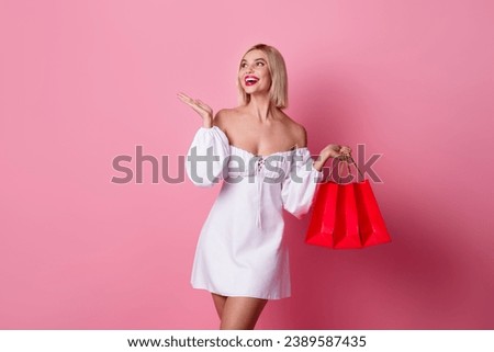Portrait of nice woman with bob hairstyle wear white dress hold new outfit look presenting empty space isolated on pink color background